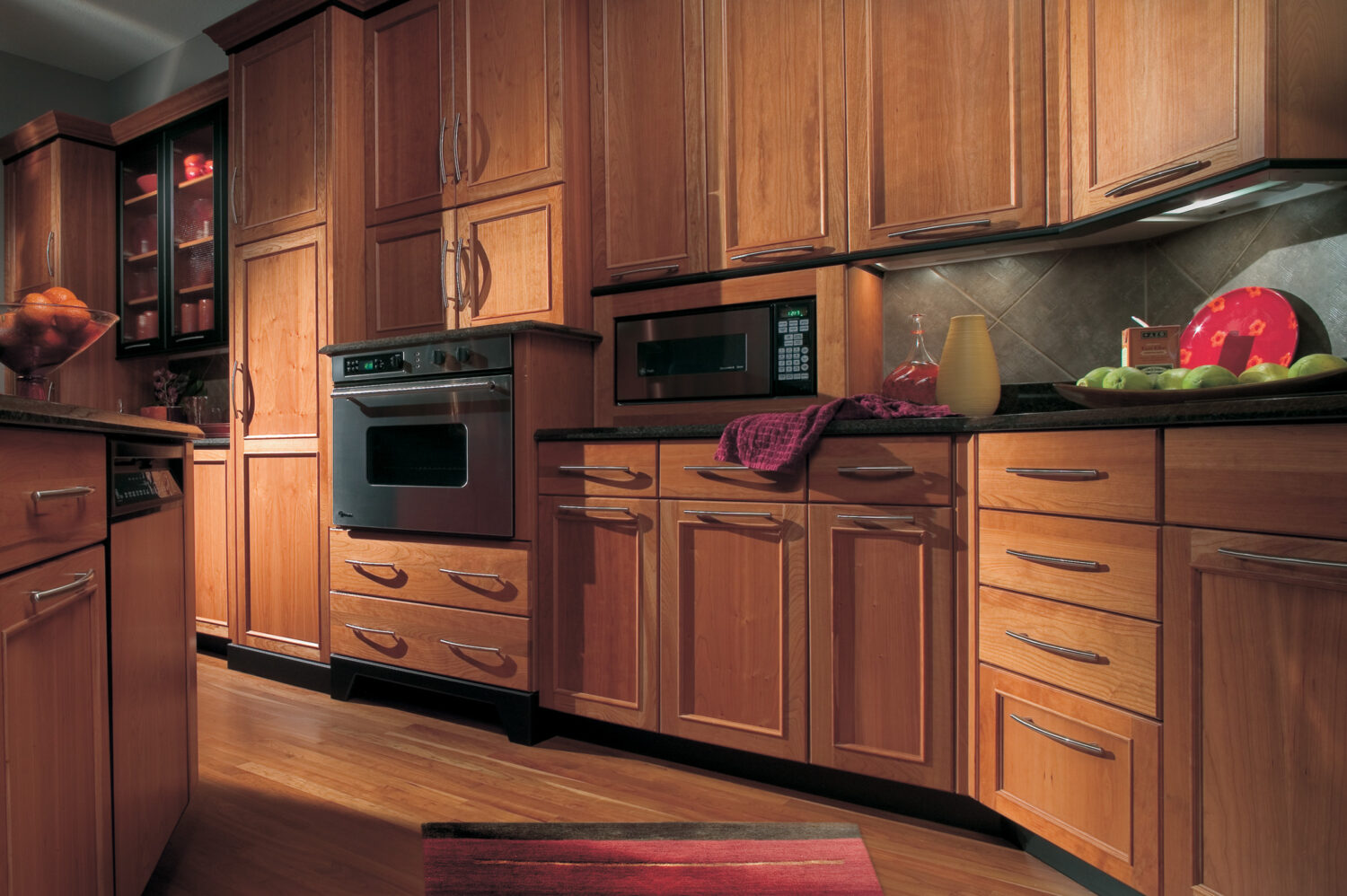 This practical and intelligent cherry wood kitchen design creates cabinetry that performs as beautifully as it looks. This kitchen remodel has a modern style yet maintains a warm cozy color palette.