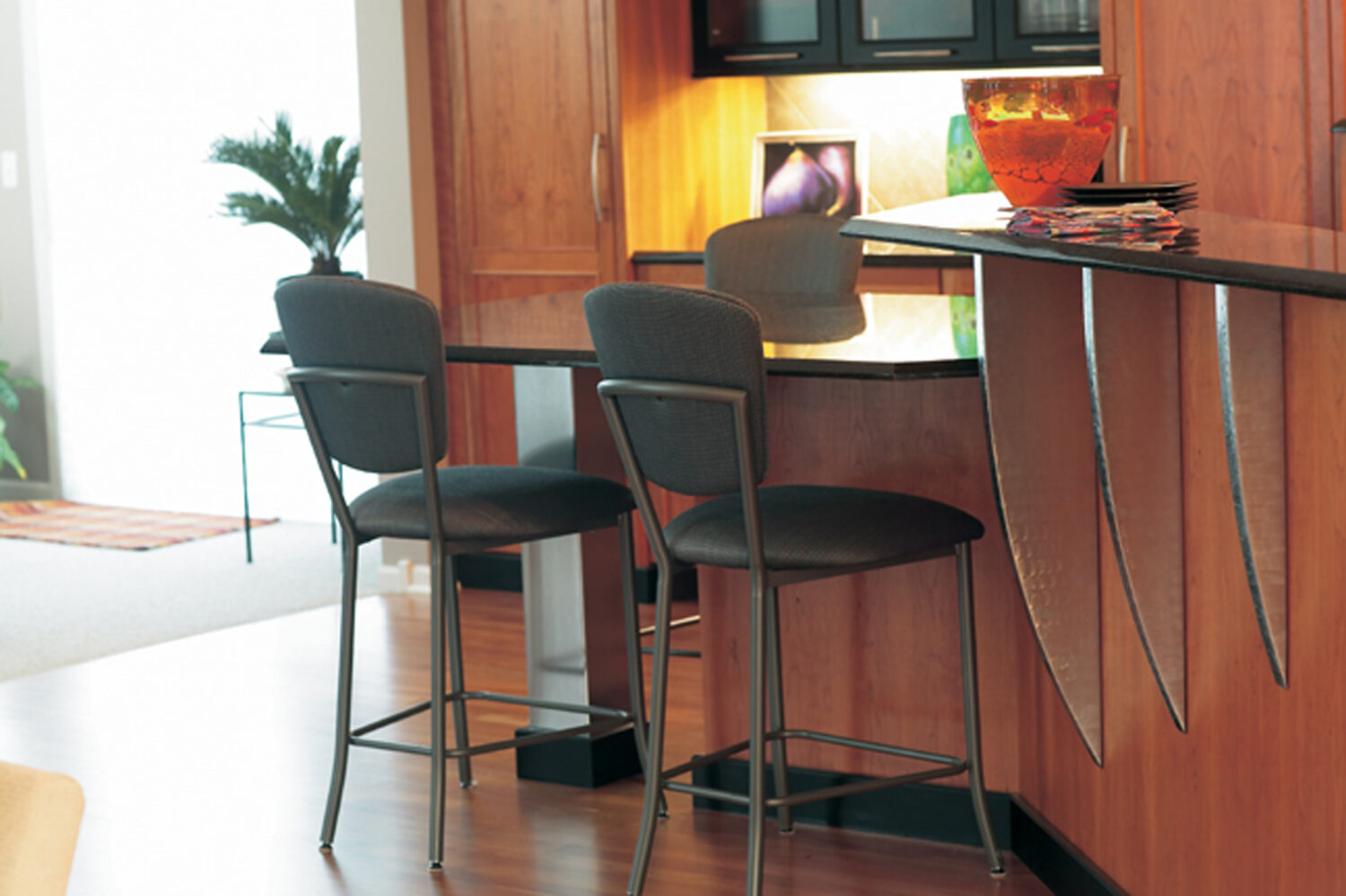 A multi-level kitchen island with contemporary seating using metal corbels to support the countertop overhangs.