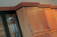 Two toned crown molding at the top of kitchen cabinets in a cherry wood kitchen with a transitional style.
