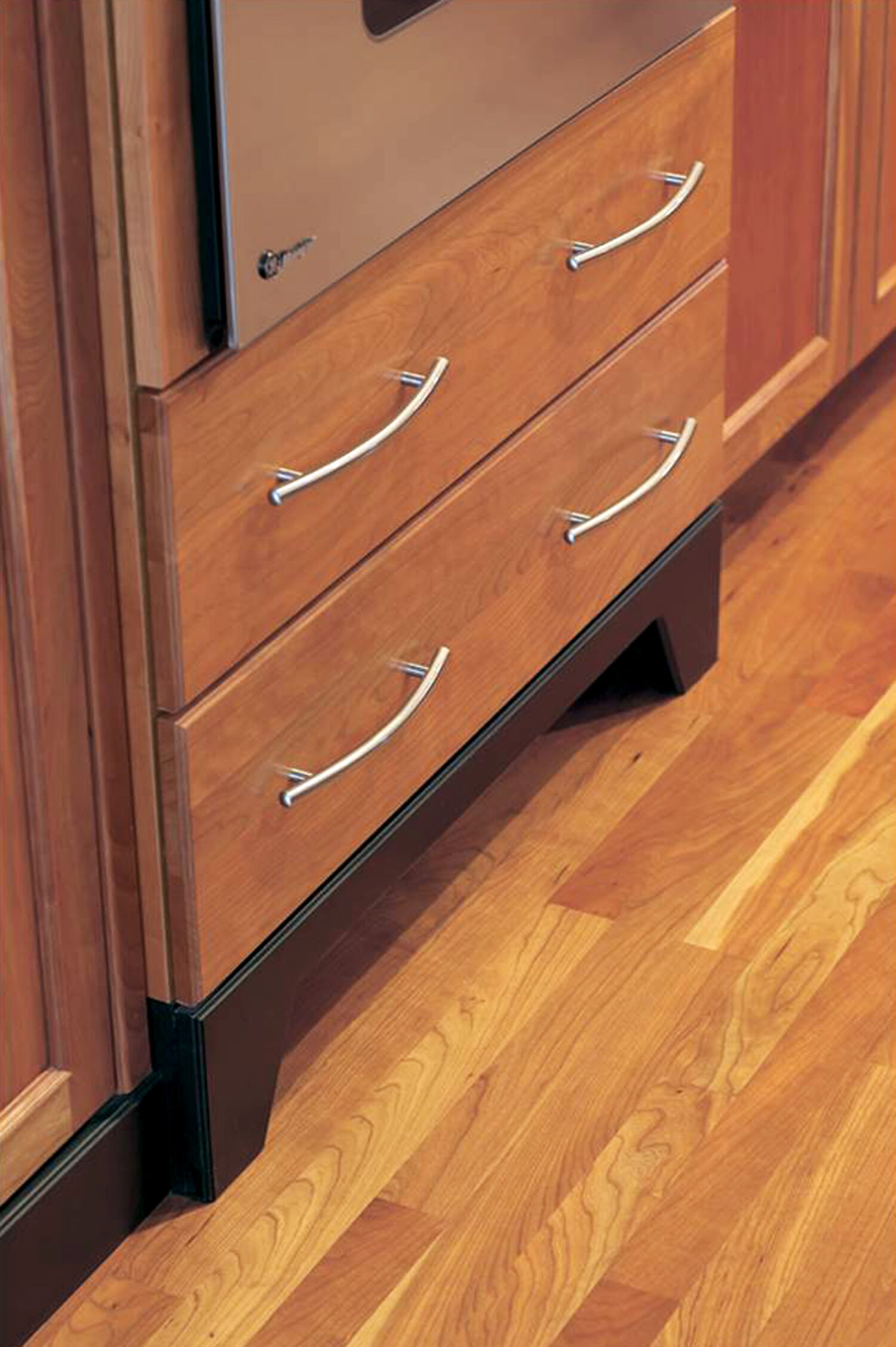 A close up of warm stained cherry cabinets in a contemporary kitchen renovation.