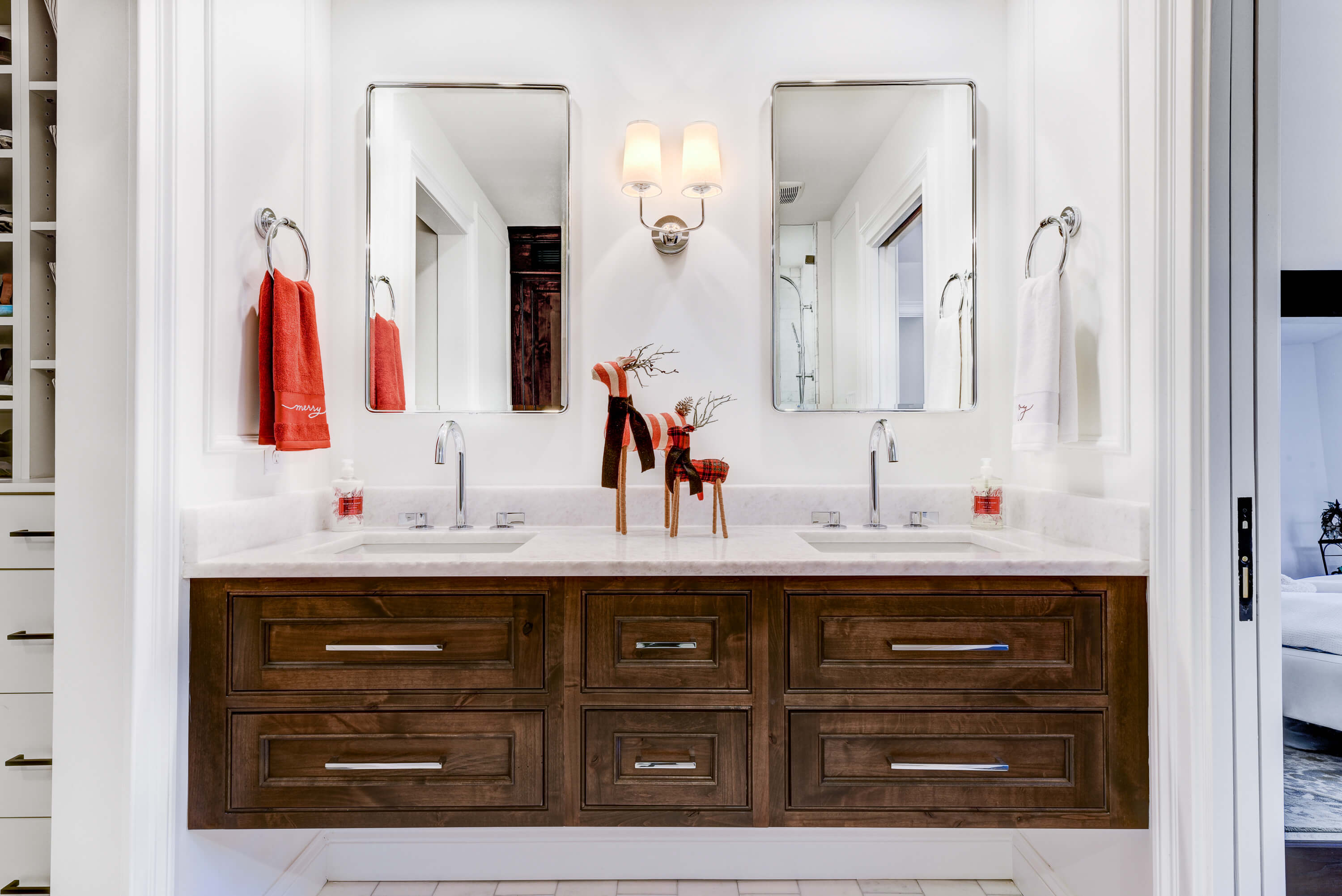 A warm, knotty alder floating bath vanity with inset cabinet doors in a remodeled master bathroom. This bath is decorated with festive red, reindeer holiday decor.