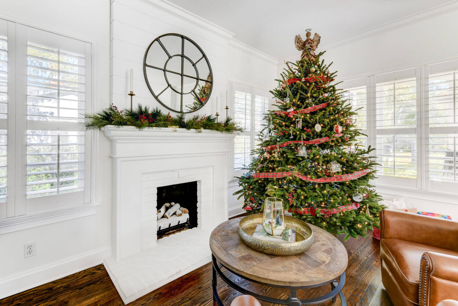 All decorated for Christmas, this bright white home has an all white fireplace mantel with a white hearth that coordinates with kitchen cabinets and countertops.