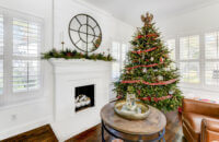 All decorated for Christmas, this bright white home has an all white fireplace mantel with a white hearth that coordinates with kitchen cabinets and countertops.