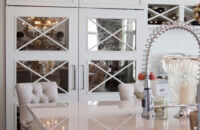 Antique mirror cabinet doors with an X mullion used on an appliance paneled appliance to hide the refrigerator.