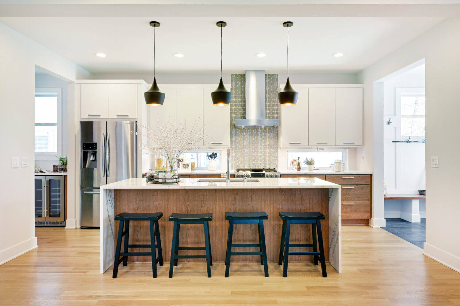 A cutting-edge modern kitchen remodeled with frameless full overlay cabinets from Dura Supreme with a waterfall kitchen island and two toned cabinetry.