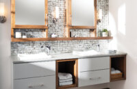 A two-toned floating vanity with light gray paint and warm stained wood with open storage and a floating shelf connecting to the dual medicine cabinets with a modern design.