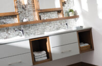 A two-toned floating vanity with light gray paint and warm stained wood with open storage and a floating shelf connecting to the dual medicine cabinets with a modern design.