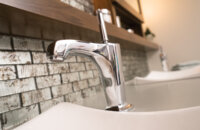 An off-set bathroom sink faucet in a modern bathroom.