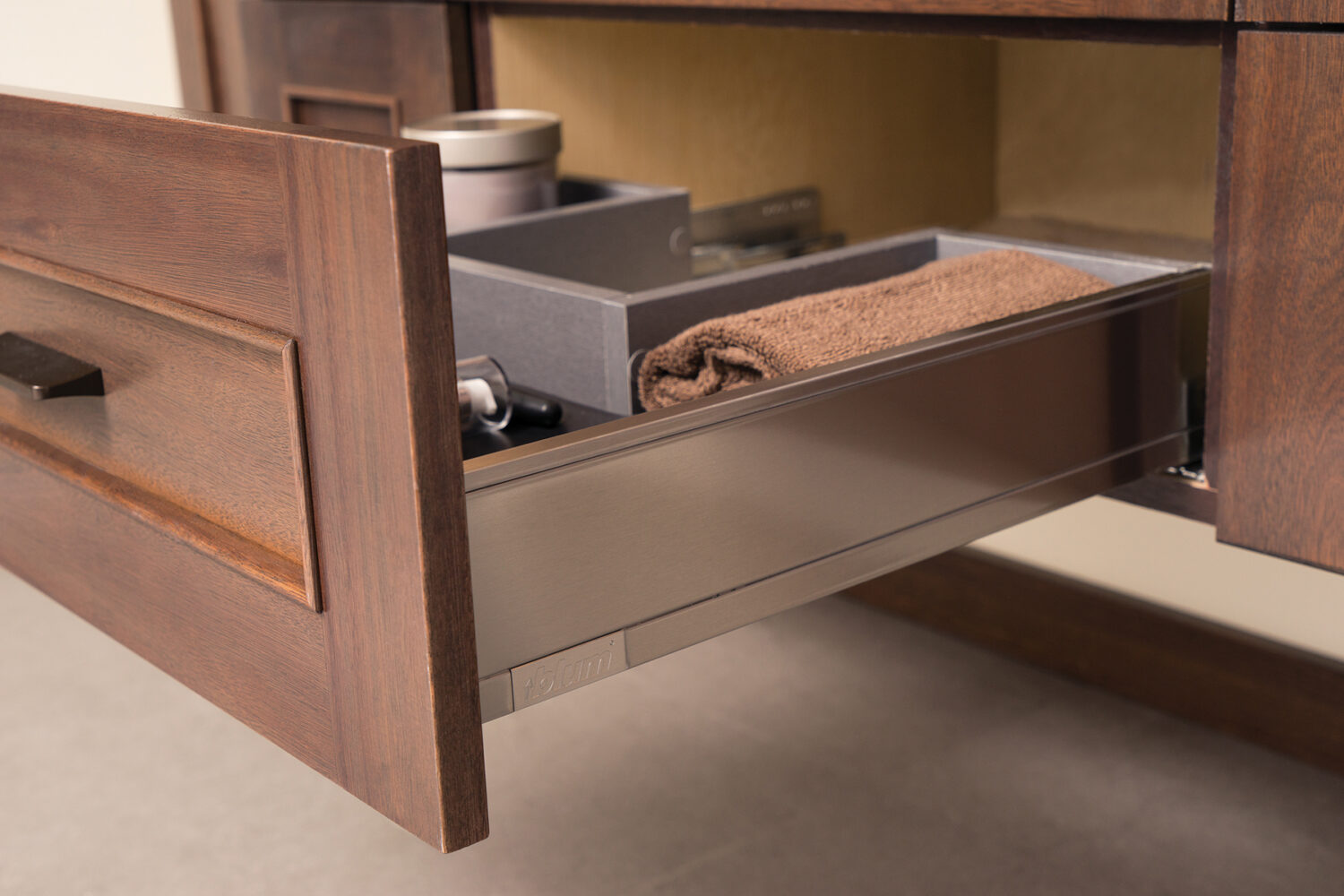 A stainless steel plumbing drawer on a floating vanity cabinet designed to add accessible storage around the plumbing fixtures right below the bathroom sink. This is a great modern cabinet storage solution and is easy to clean.