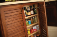 A Shallow Cabinet can be easily added to the end of an island or a peninsula creating a space fully dedicated to your spice collection. This tropical styled kitchen island features Dura Supreme Cabinetry.