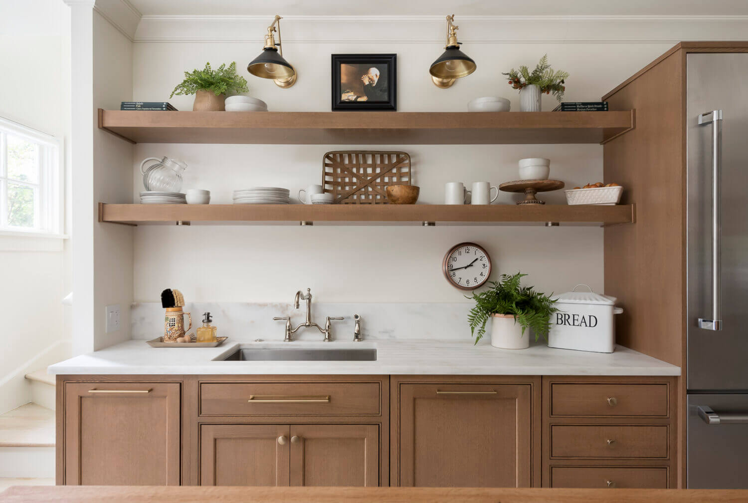 A wall with light oak base cabinets and sleek, simple floating shelves instead of wall cabinets.