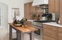 A Danish styled kitchen with light oak cabinets and a weathered kitchen island table.