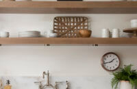 A wall with light oak base cabinets and sleek, simple floating shelves instead of wall cabinets.