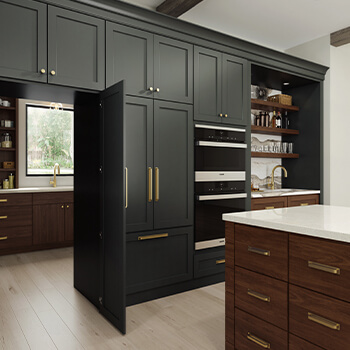 A walk-in pantry hidden behind cabinet doors in a modern farmhouse style kitchen remodel with dark painted cabinets highlighted with warm stained accents and a kitchen island.