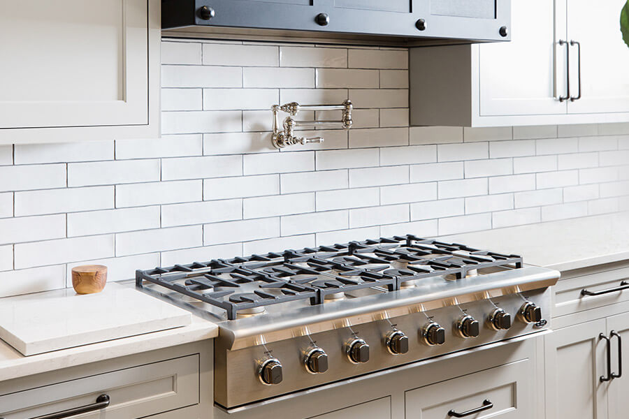 The Cook Zone is the primary work zone within the kitchen where the food is actually being cooked. This cooktop area has a pot filler and a large metal hood. There is plenty of free counterspace on both sides of the cooktop for a work surface. Deep drawers below offer lots of storage for pots & pans.
