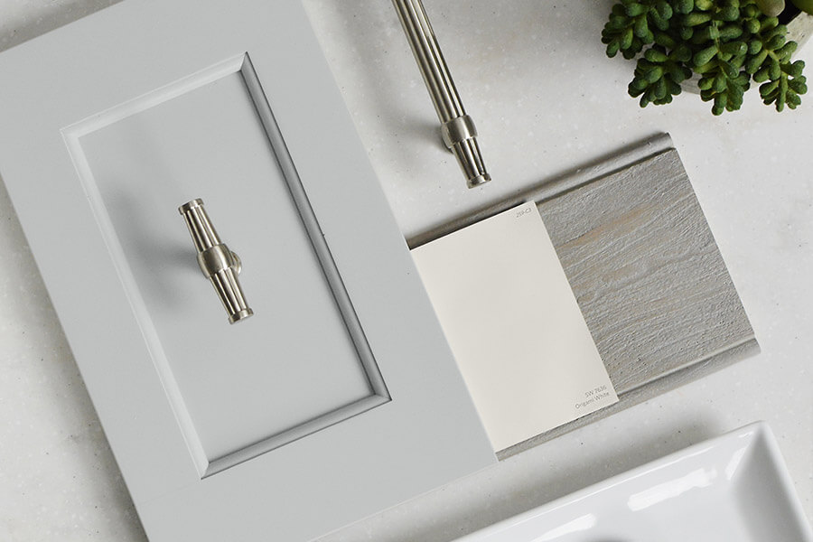A light gray painted cabinet door style with a flat panel and sleek profiles paired with a gray stained weathered wood. This casual style bathroom concept is classic and transitional. With Transitional being between Traditional and Contemporary, you’ll find many styles under this design category.