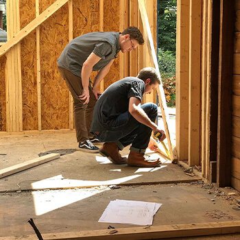 Remodelers hard at work adding an addition to a home to expand the kitchen design. During a remodel, your home is in a momentary state of construction, but is still a space in which you need to live until the process is complete. Your Dura Supreme designer is here to help you navigate that process and help you think through tasks like packing up your kitchen, setting up a temporary kitchen, and more.