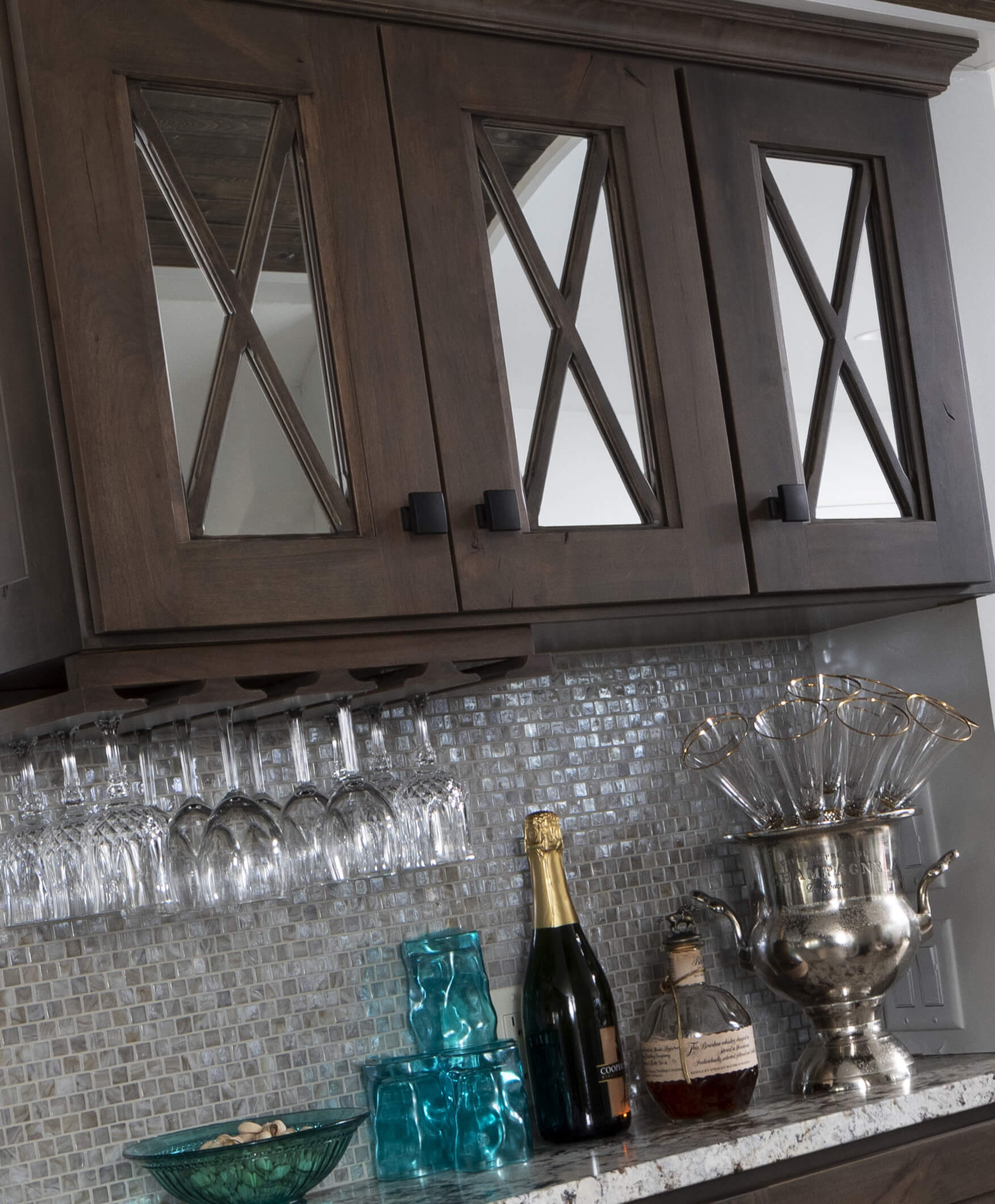 A close up of dark stained cabinets with mirror mullion cabinet doors.