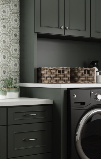 Create a custom paint color for your cabinets with Dura Supreme Cabinetry. This dark green painted laundry room was remodeled with custom paint match to Sherwin-Williams 