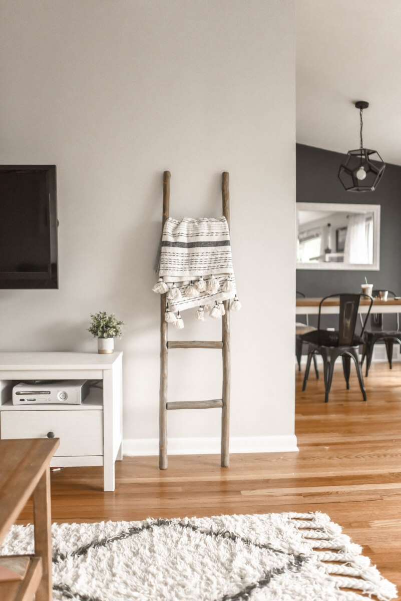 Danish styled rustic ladder holding a woven blanket.