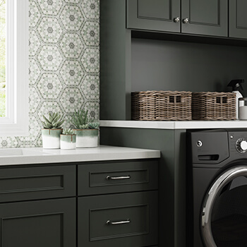 Full overlay cabinet door construction shown on dark green painted laundry room cabinets in a modern farmhouse remodel. A Full Overlay door style overlaps the face frame of the cabinet by 1 1/4″, leaving a 1/4″ of the face frame exposed.