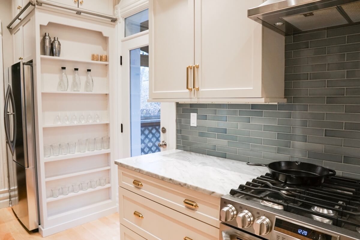 The side of the refrigerator has a thin tall cabinet with open shelves for barware, spices, and canned good storage