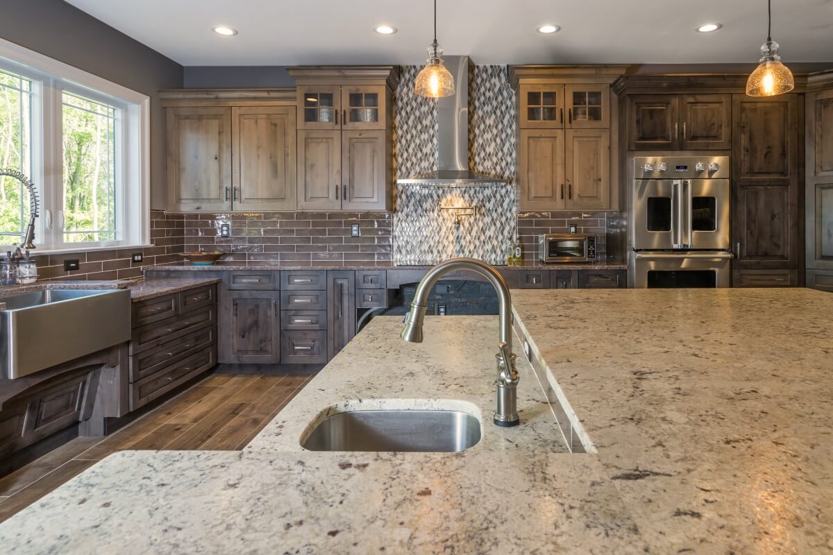 A rustic kitchen design with wheel chair accessible kitchen island, kitchen sink, cooktop, and additional accessible work zones.