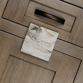 An undertone is an underlying color apparent in most colors. This inset cabinet door and quartz countertop sample both have a coordinating true-brown undertone to their colors.