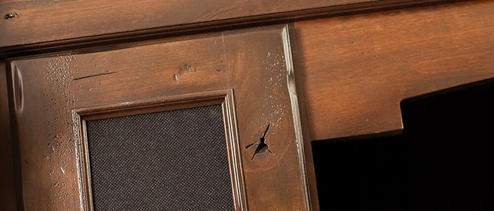 A close up of distressed stained cabinets with a patina finish from Dura Supreme Cabinetry.