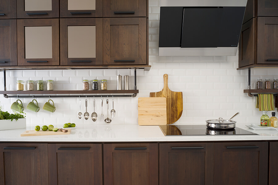 A modern industrial styled kitchen with darker stained cherry cabinets. Featuring full access “frameless” construction, Bria Cabinetry blends high-tech with high-fashion. Bria delivers hand-crafted quality with expansive styling choices, from traditional to chic contemporary.