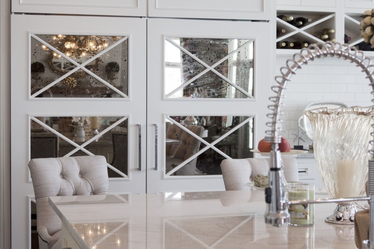 Mirror cabinet doors reflect additonal light into the space and add beautiful feature. Dura Supreme Cabinetry design by Nanci Marsman of Standale Interiors, Michigan.