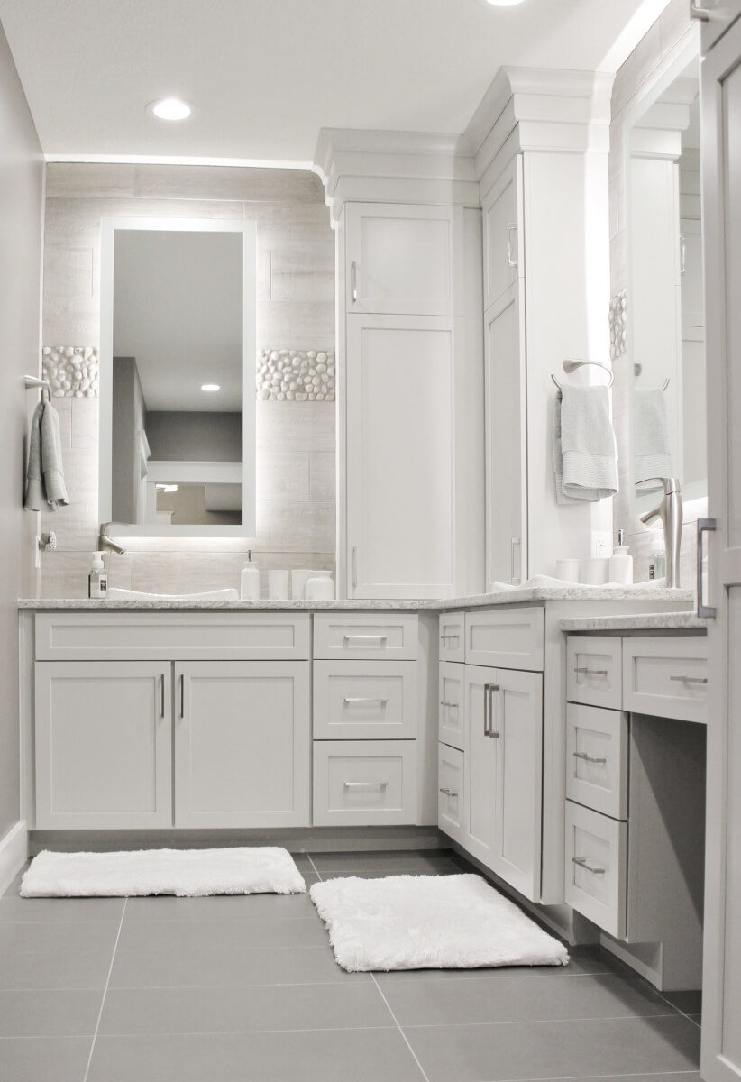 A stunning bright white master bathroom with a light white-gray painted vanity.