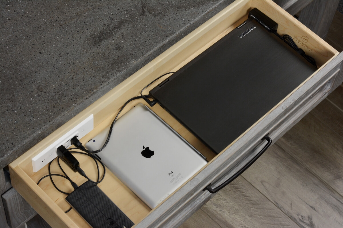 A home office drawer with a charging station to power and store devices like laptops, tablets, mobile phones, and more.