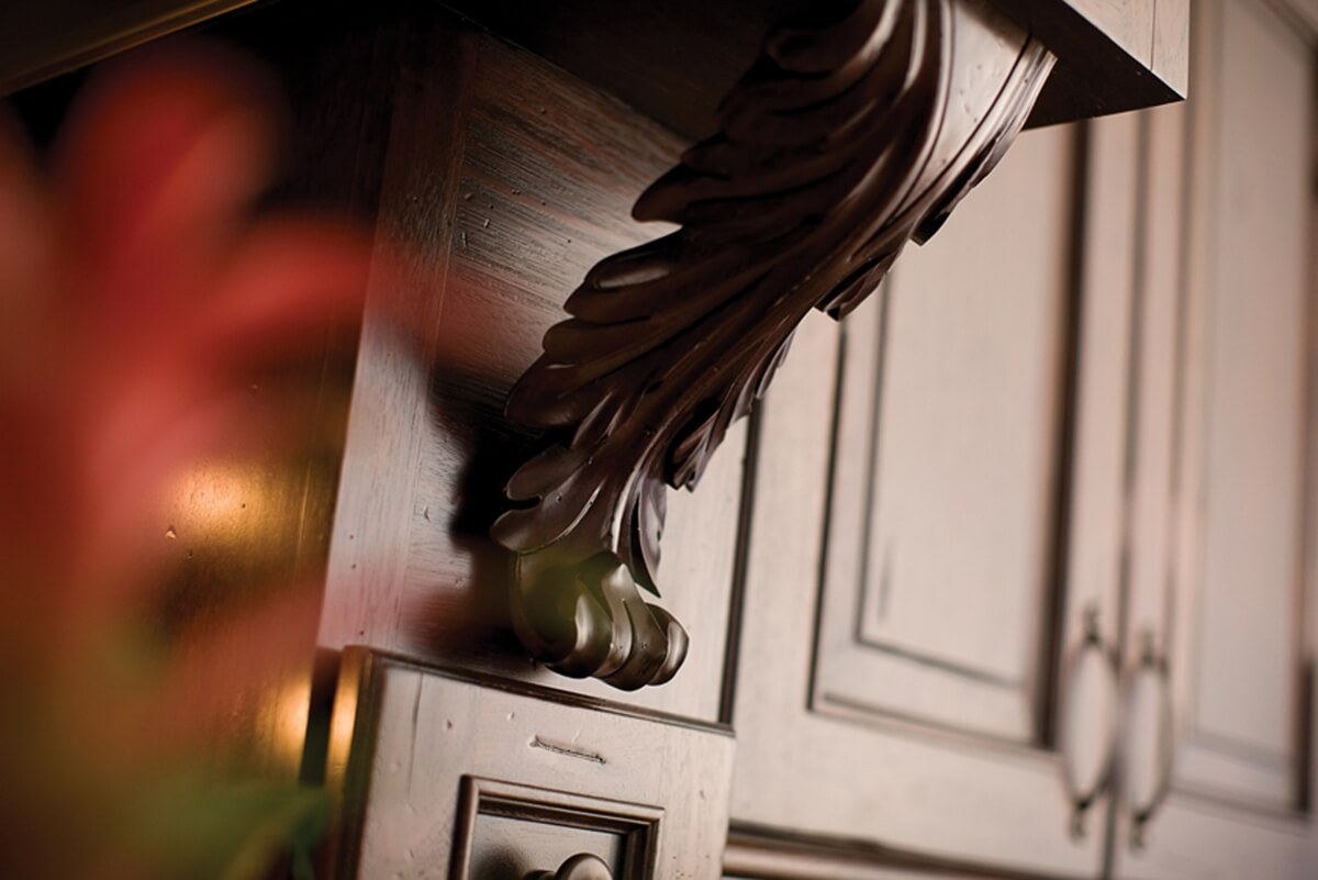 A corbel shaped like a palm frond was selected to add a West Indies look to the mantel hood above the cooktop.