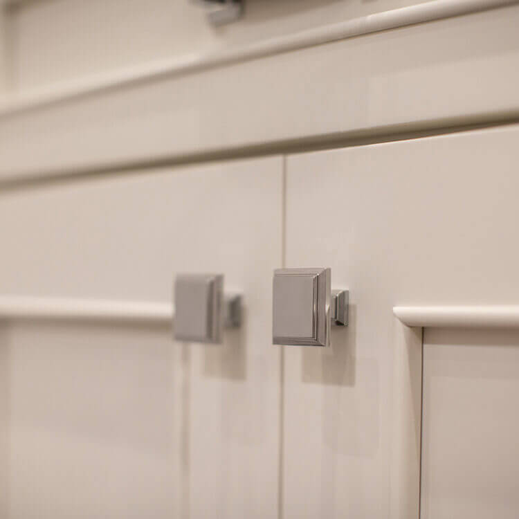 A close of the white painted cabinets with a beautiful, simple molding that emphasizes the flat panel door style.