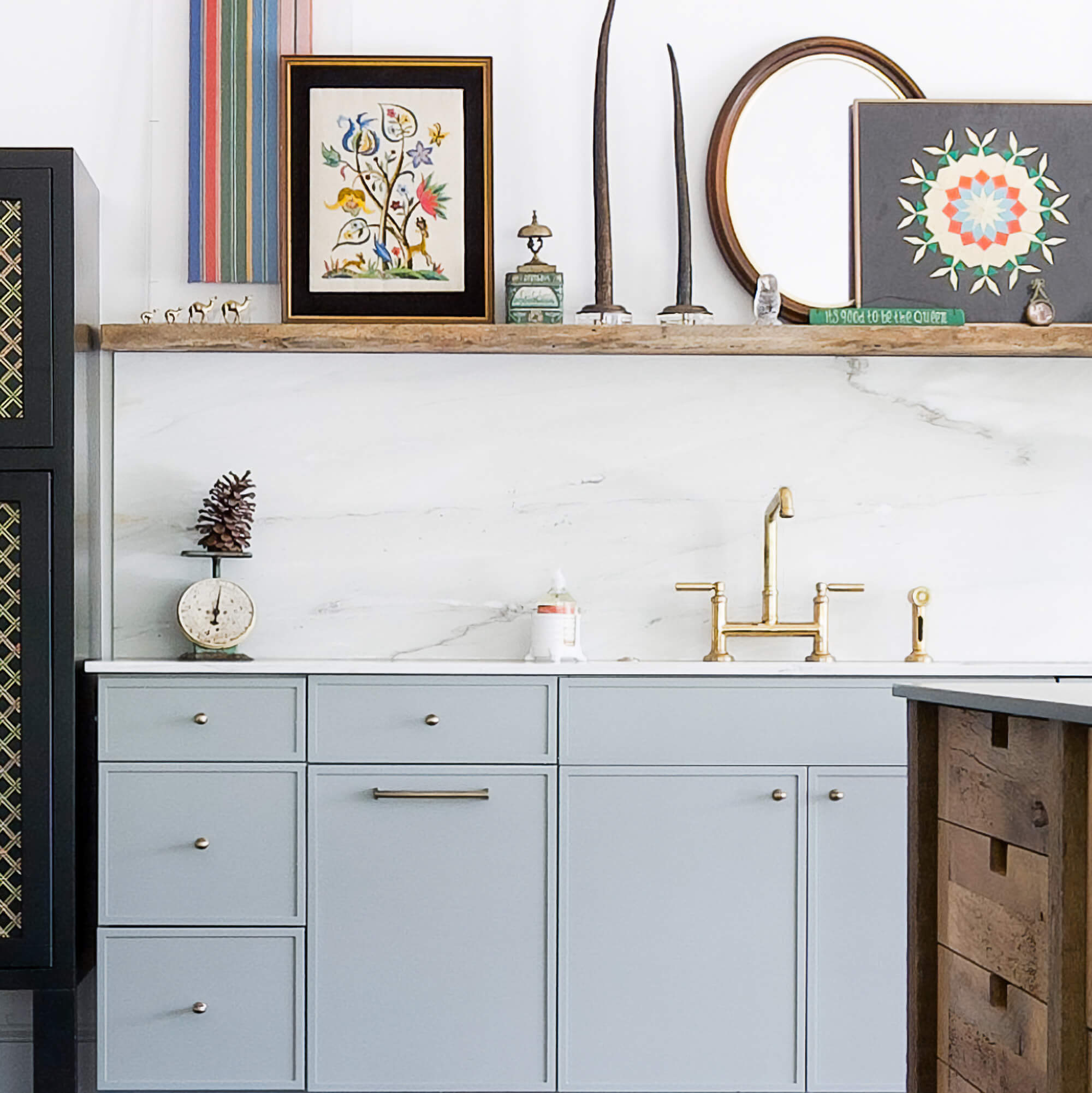 A light blue Scandinavian Style kitchen with cabinet doors and rustic wood accents and floating shelf.