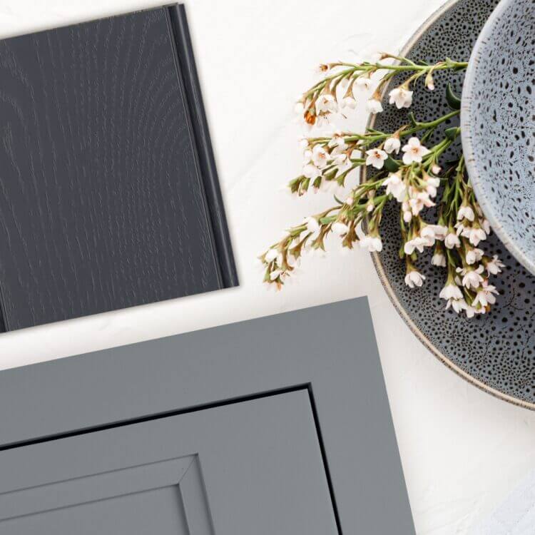 Kitchen cabinet design trends for painted cabinets include deep blues and gray hues. This kitchen desing concept features a deep navy blue pained finish on red oak with a wood texture and an inset cabinet door with a trendy gray painted color.