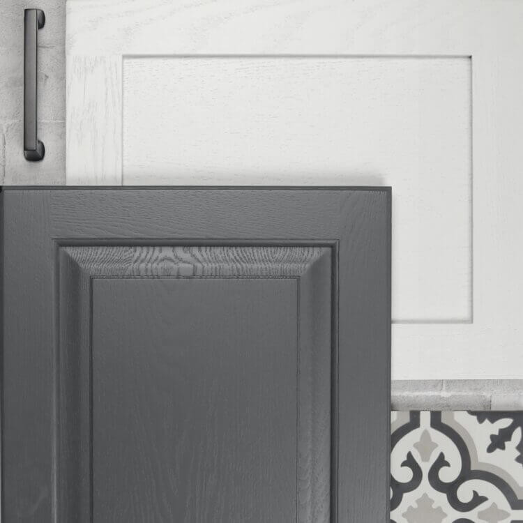 A close up of two cabinet doors with a painted oak finish showing the texture of the wood grain through the sleek layer of paint.