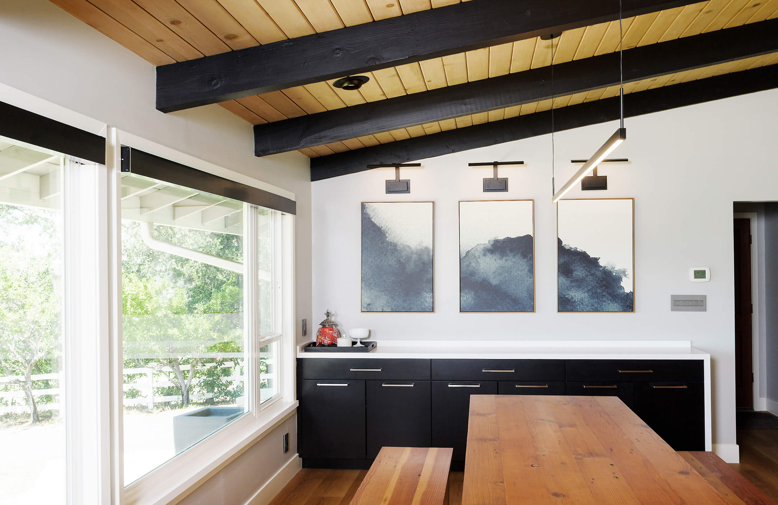 A black and white Scandinavian style kitchen and dining room with vaulted ceilings.