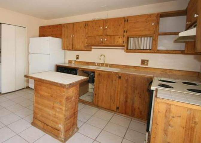 An ugly kitchen design with a terrible kitchen island design that is too small for the space.