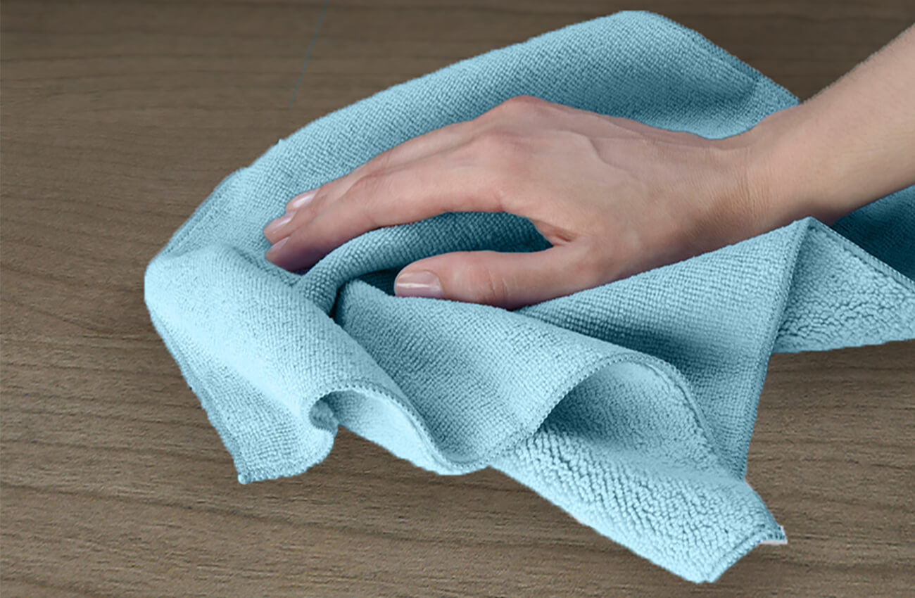 Clean your kitchen or bath cabinets with a clean, soft, lint-free cloth to remove construction dust. Never use an abrasive cleanser or a dry paper towel, as these can cause scratches to the finish. A microfiber cloth like the one shown here is a great option for cleaning cabinets with.