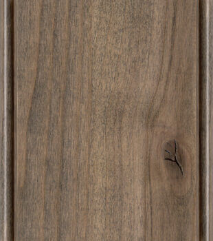 This finish color for rustic Knotty Alder kitchen & bath cabinets is shown in the Harbor stain by Dura Supreme Cabinetry. A medium cabinet color with a neutral and raw brown-gray undertone.