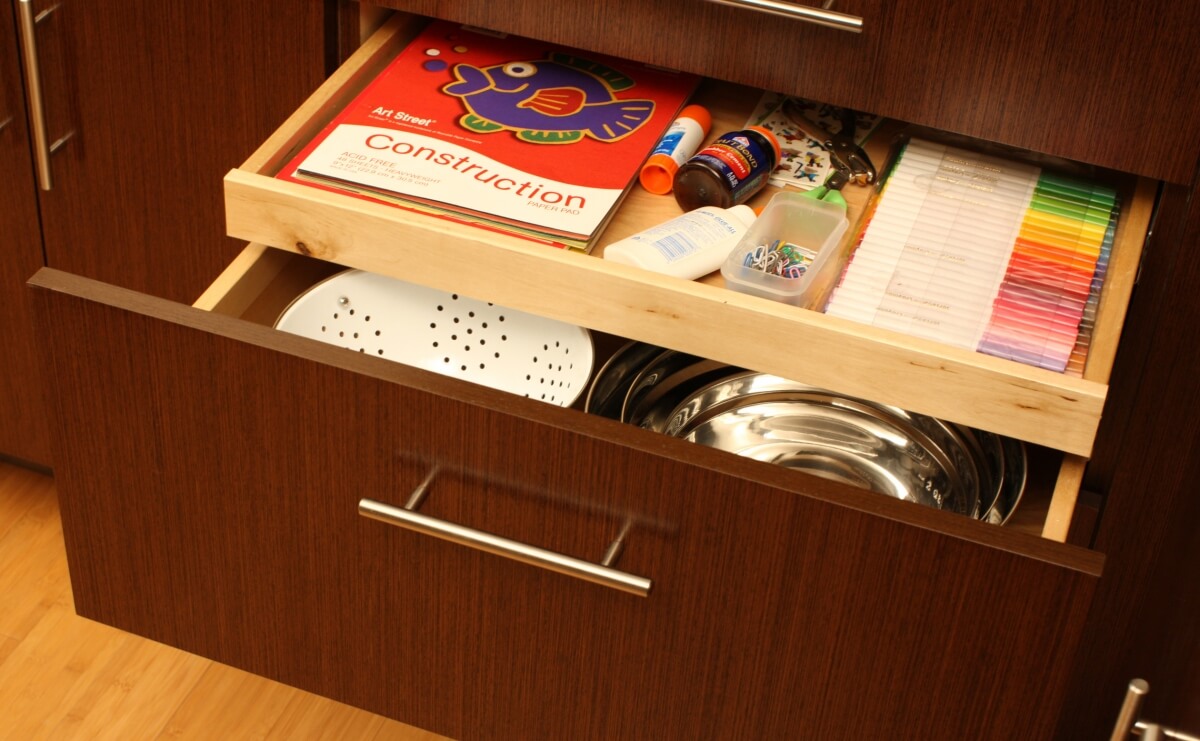 A deep kitchen drawer with an extra layer of storage with a roll out for misc. supplies.