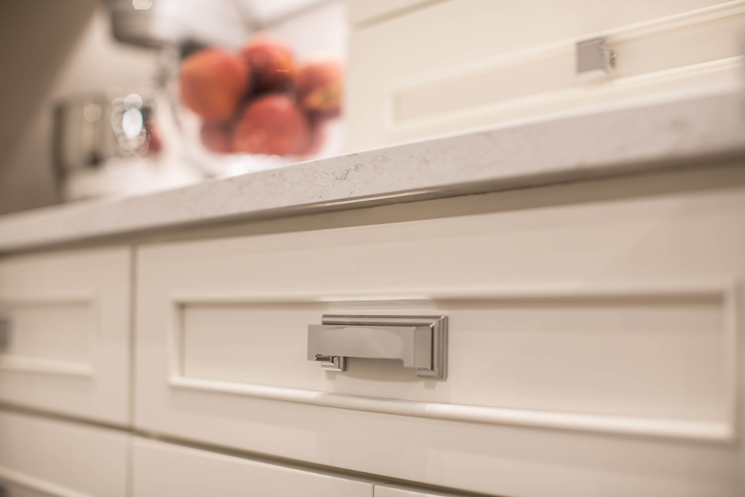 A close of the white painted cabinets with a beautiful, simple molding that emphasizes the flat panel door style.