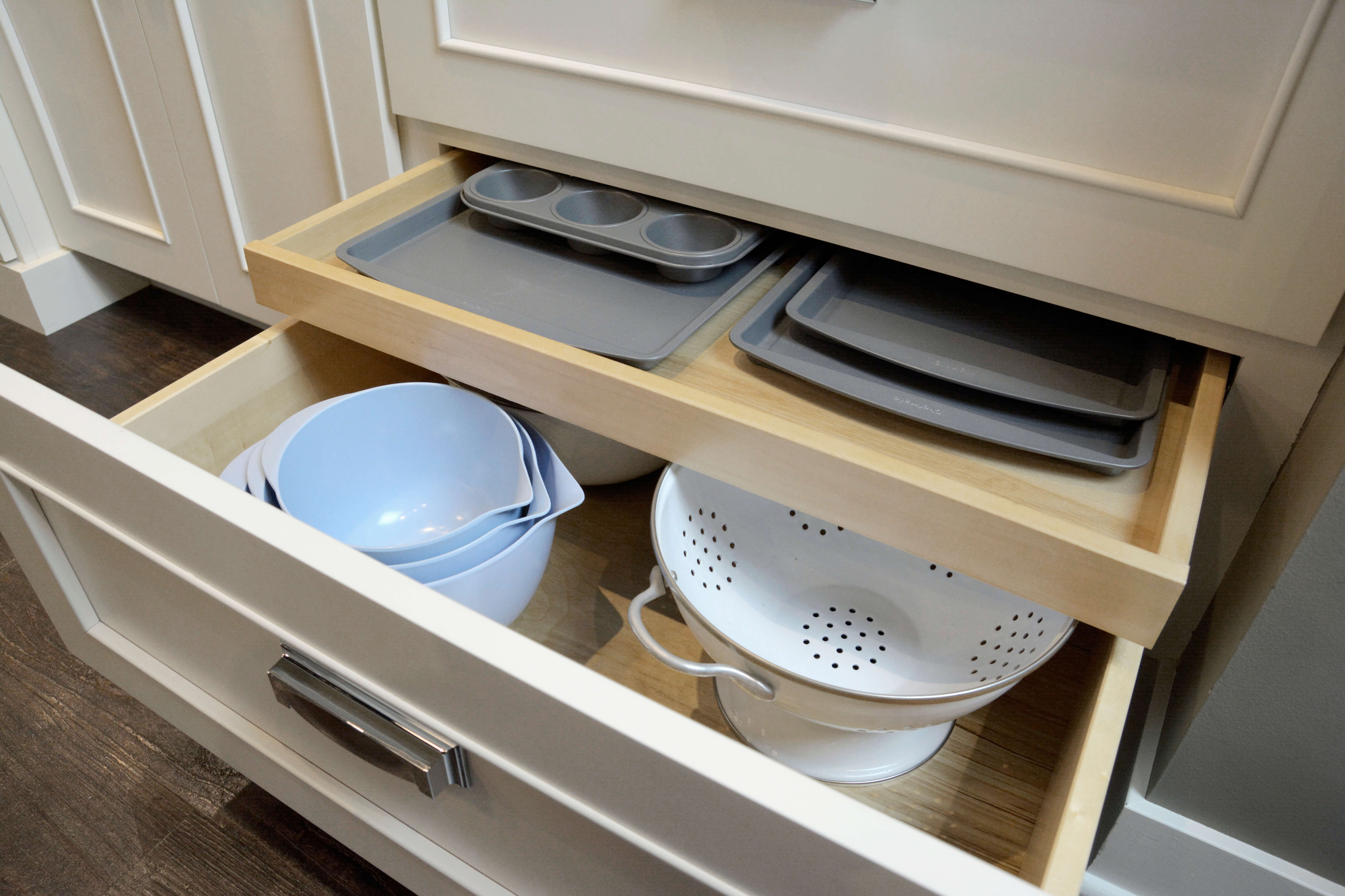 A roll-out above a deep drawer can help divide a drawer space and into two layers of storage. The top layer is perfect for muffin tins, baking trays, etc. while the lower part of the drawer can be used for strainers, mixing bowls or pots.