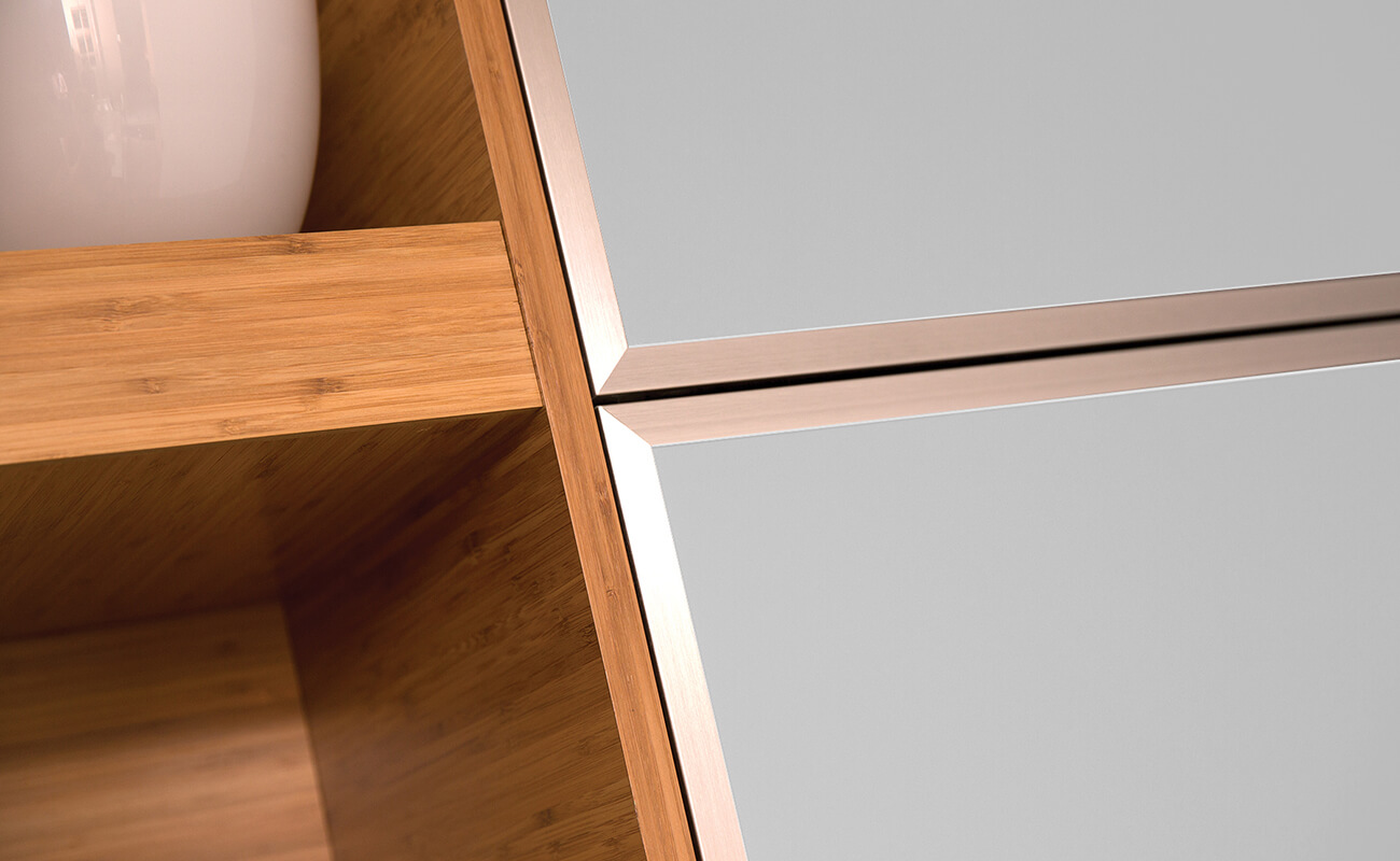 A close-up of frameless bamboo cabinets with modern aluminum framed metal accent doors.