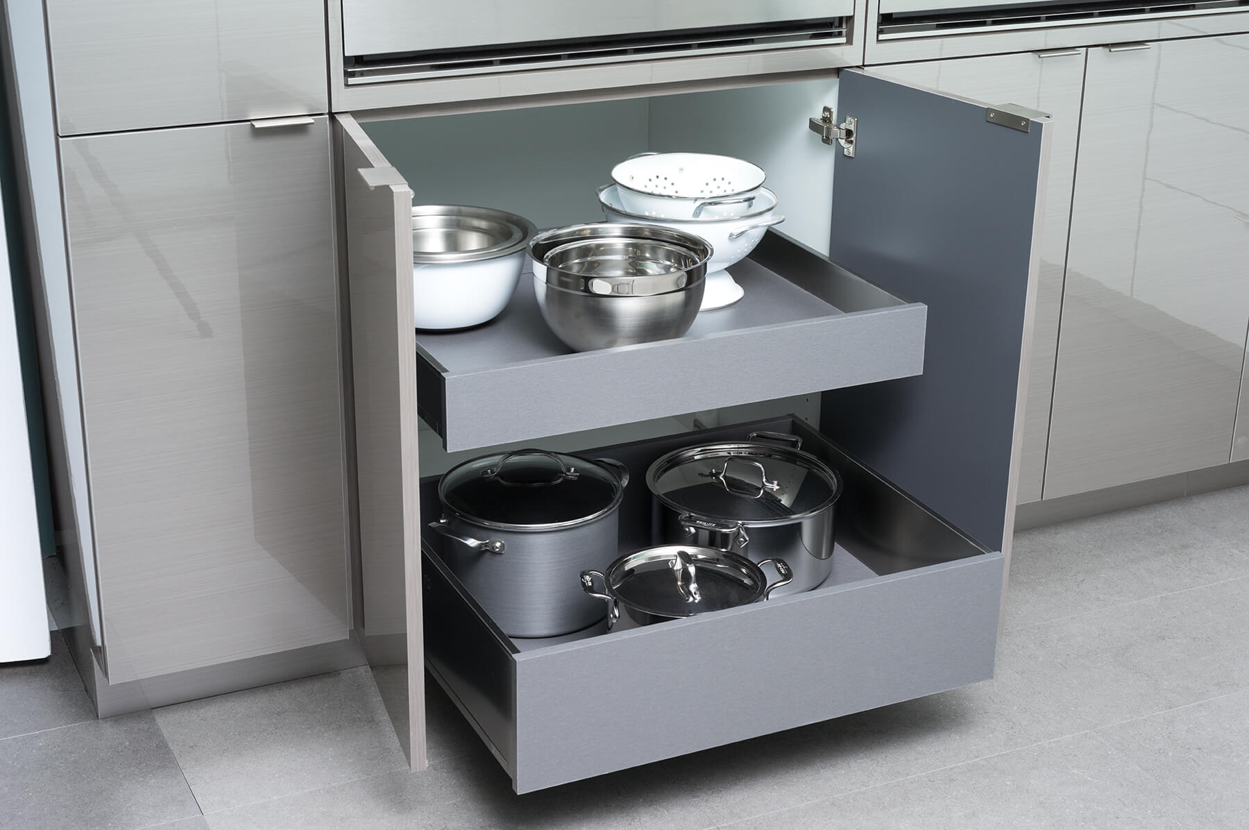 Modern stainless steel roll-out shelves in a contemporary styled base cabinet from Dura Supreme.