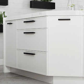 A kitchen island with bright white painted cabinets with a modern shaker door style with thin rails an stiles.