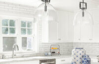 Bright white kitchen cabinets with white marble countertops.