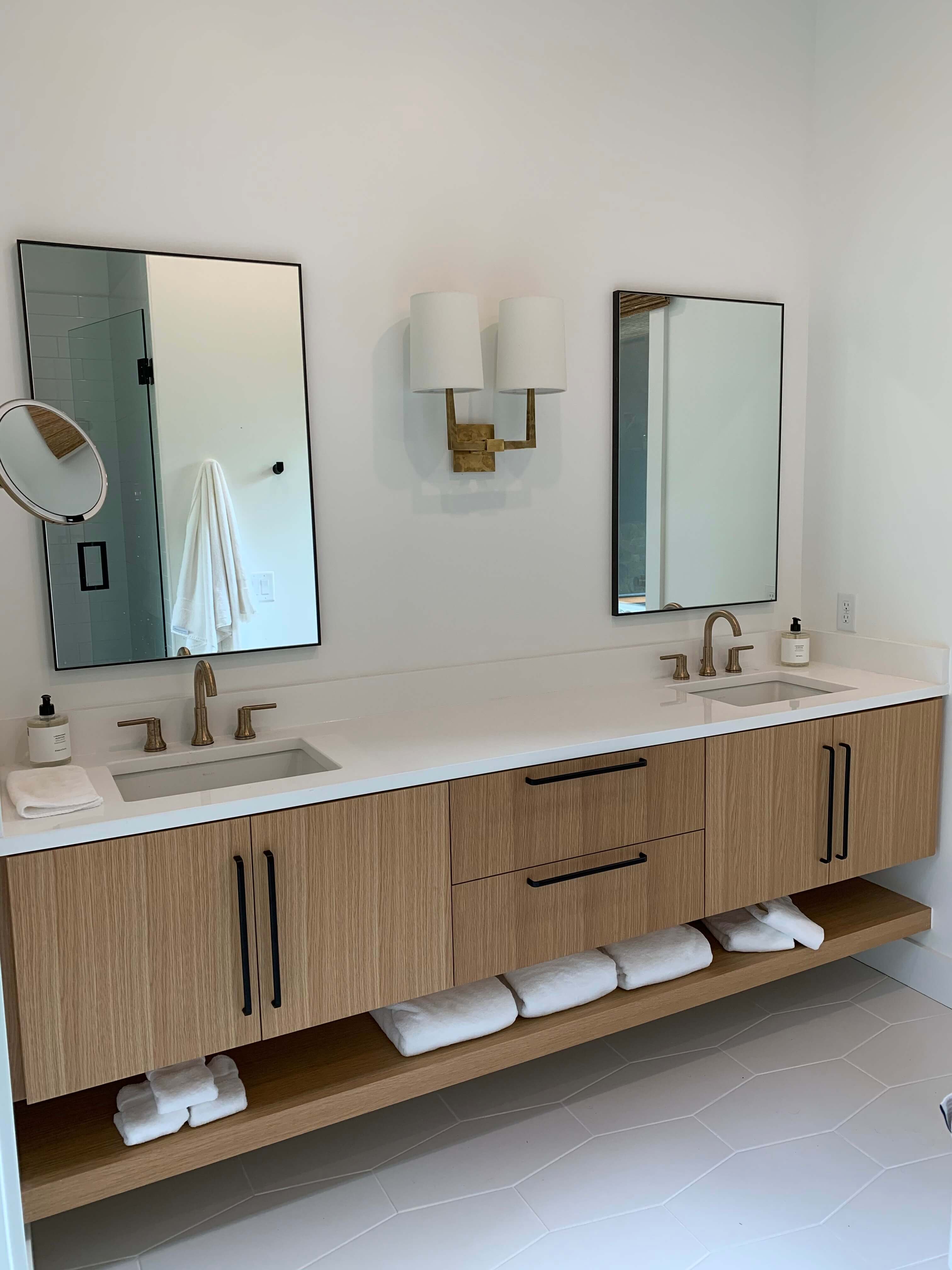 A floating vanity with a floating shelf below featuring double sinks.